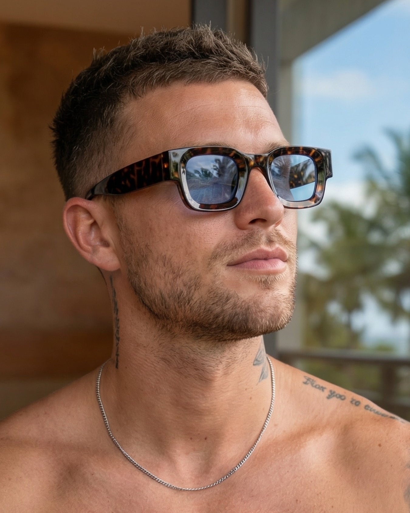 Man wearing sunglasses with a blurred outdoor background