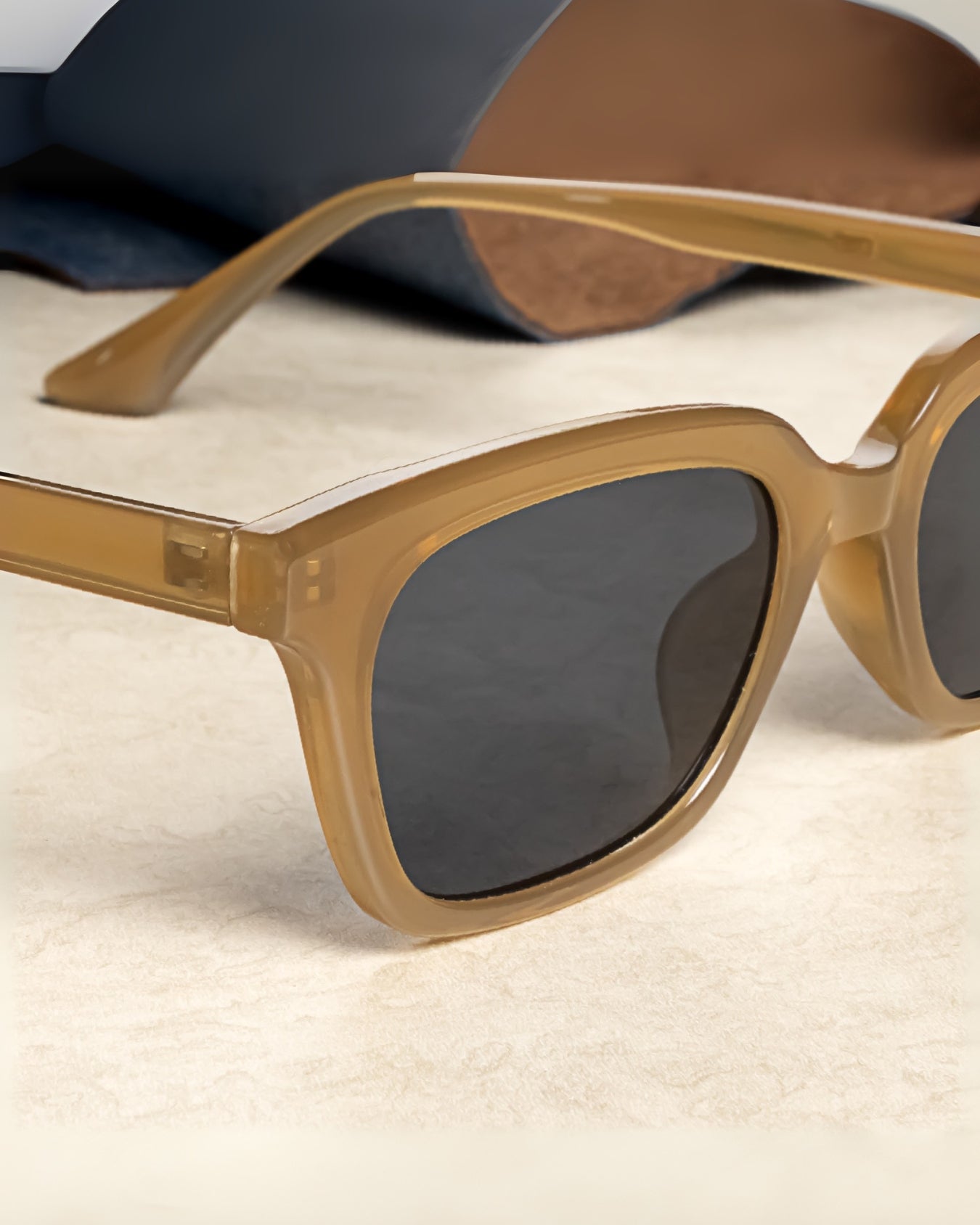 Sunglasses with gold frame and dark lenses on a light surface