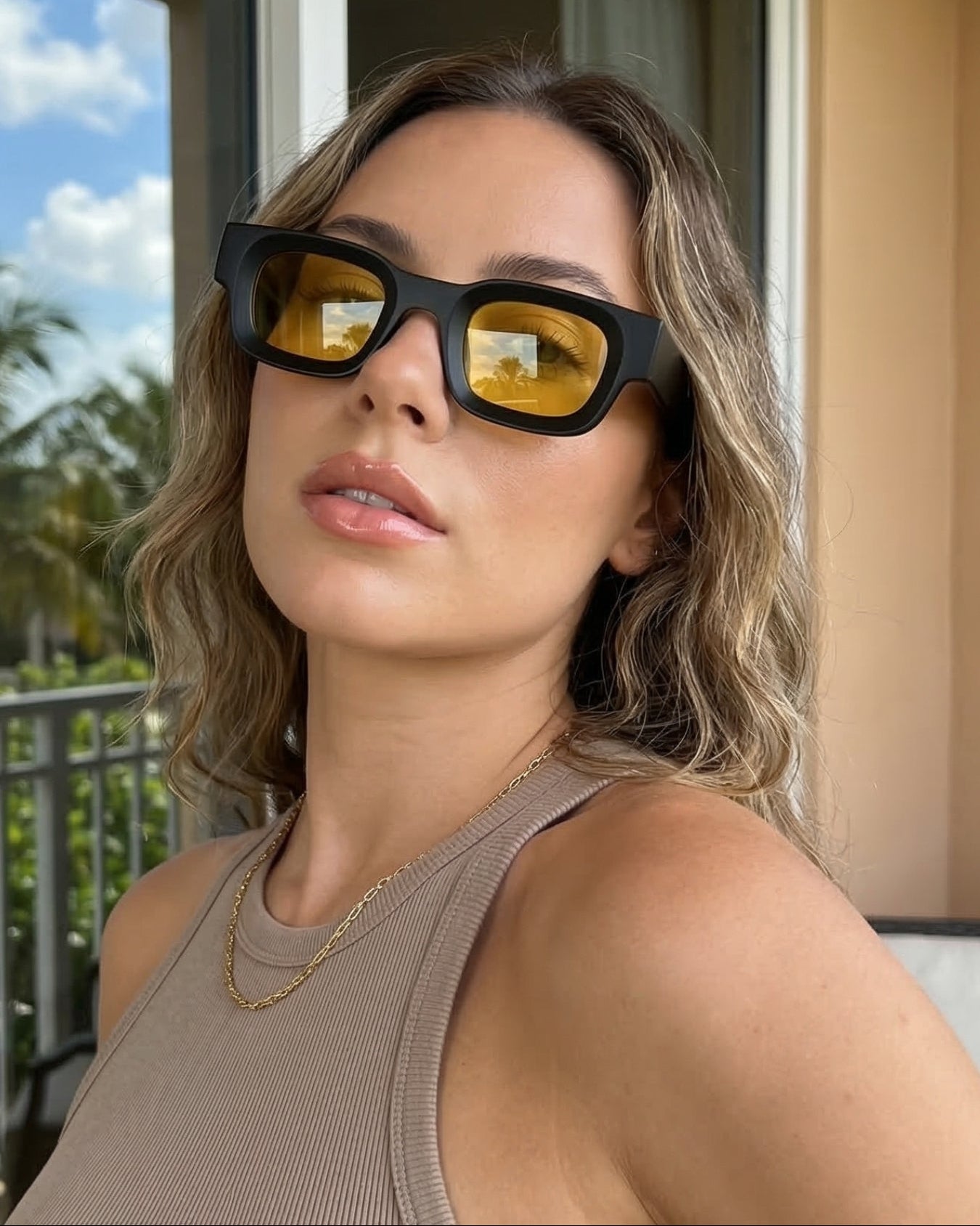 Woman wearing black sunglasses with yellow lenses outdoors