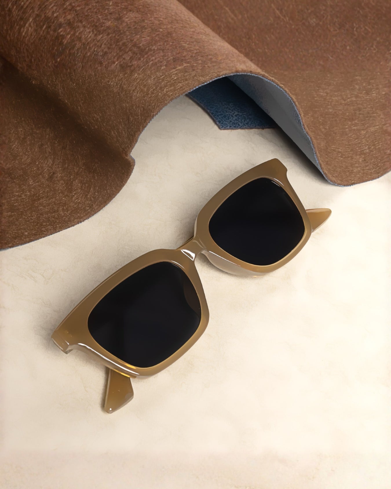Brown sunglasses with black lenses on a white surface