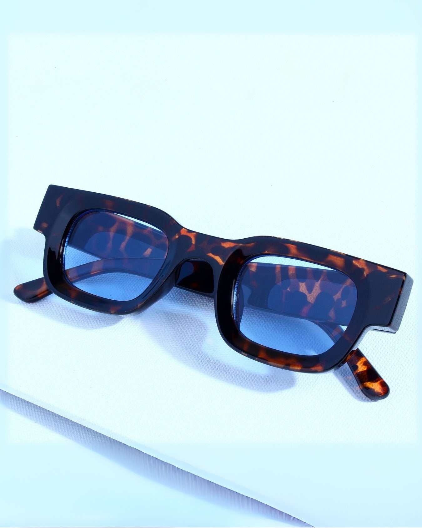 Tortoiseshell sunglasses on a light blue background