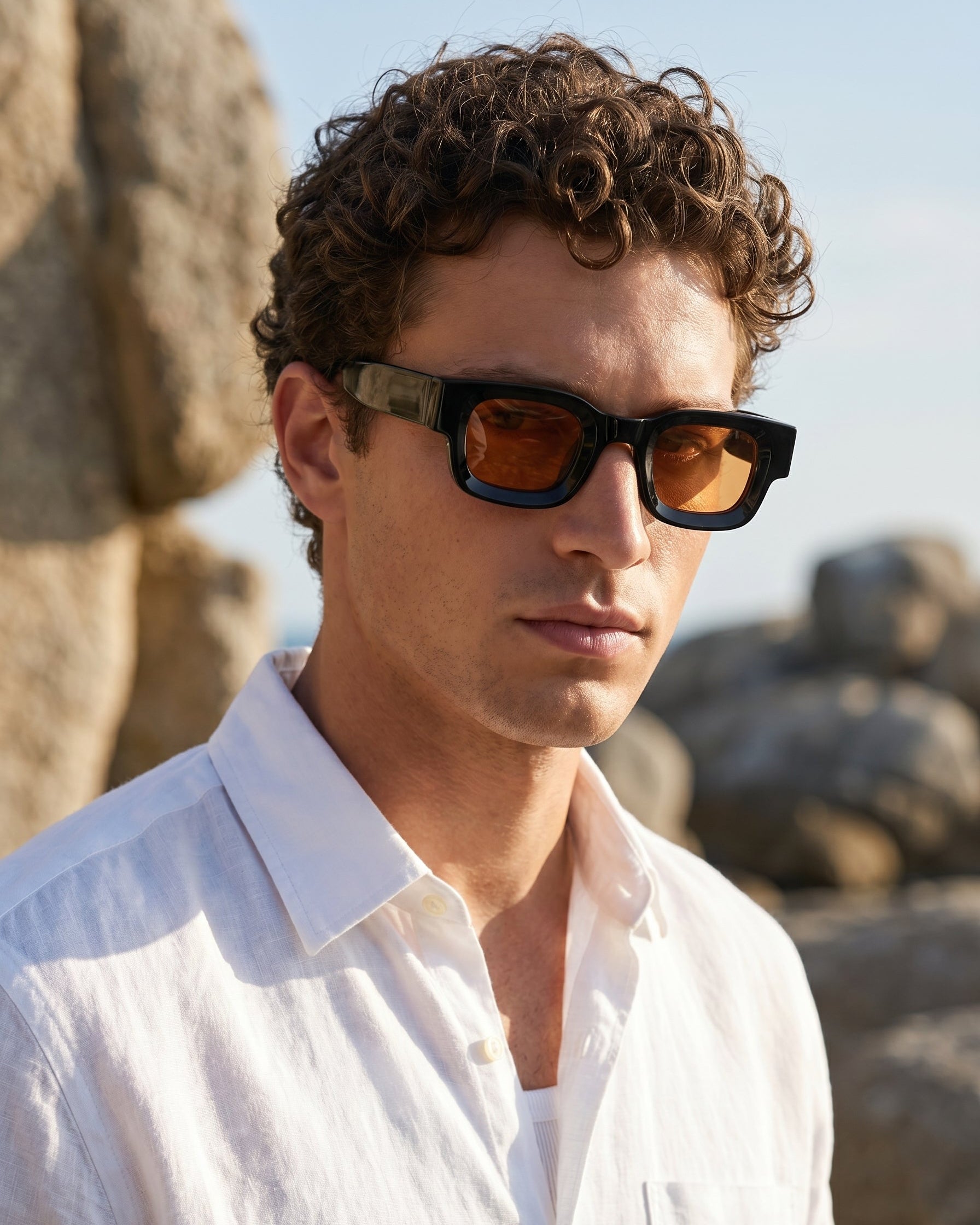 Man wearing sunglasses with a rocky background