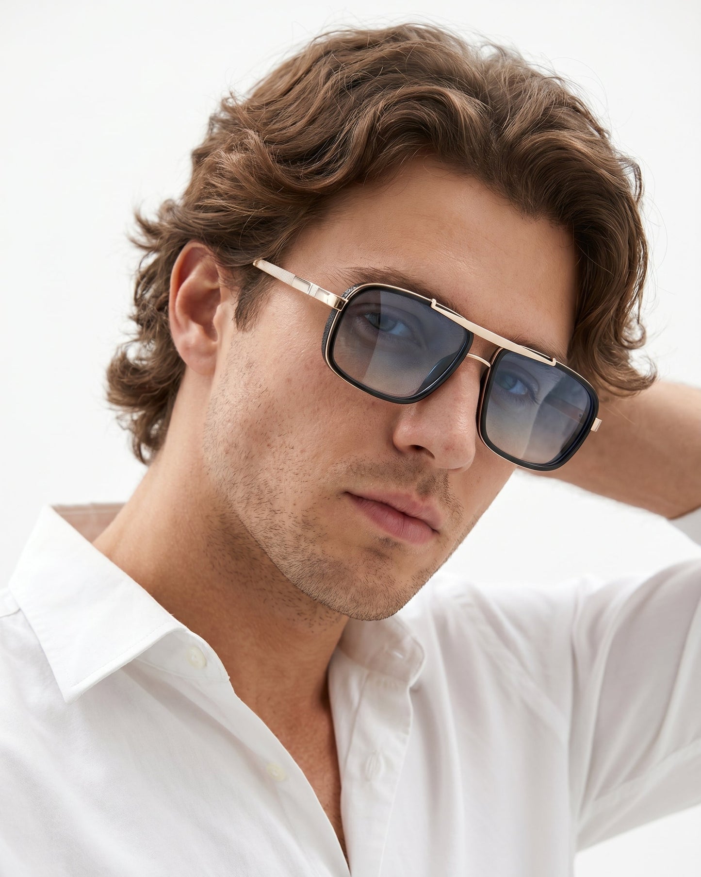 Man wearing sunglasses and a white shirt against a light background