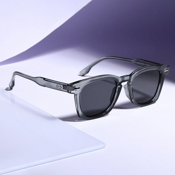A pair of square-shaped, grey frame sunglasses with black lenses, displayed on a flat surface.